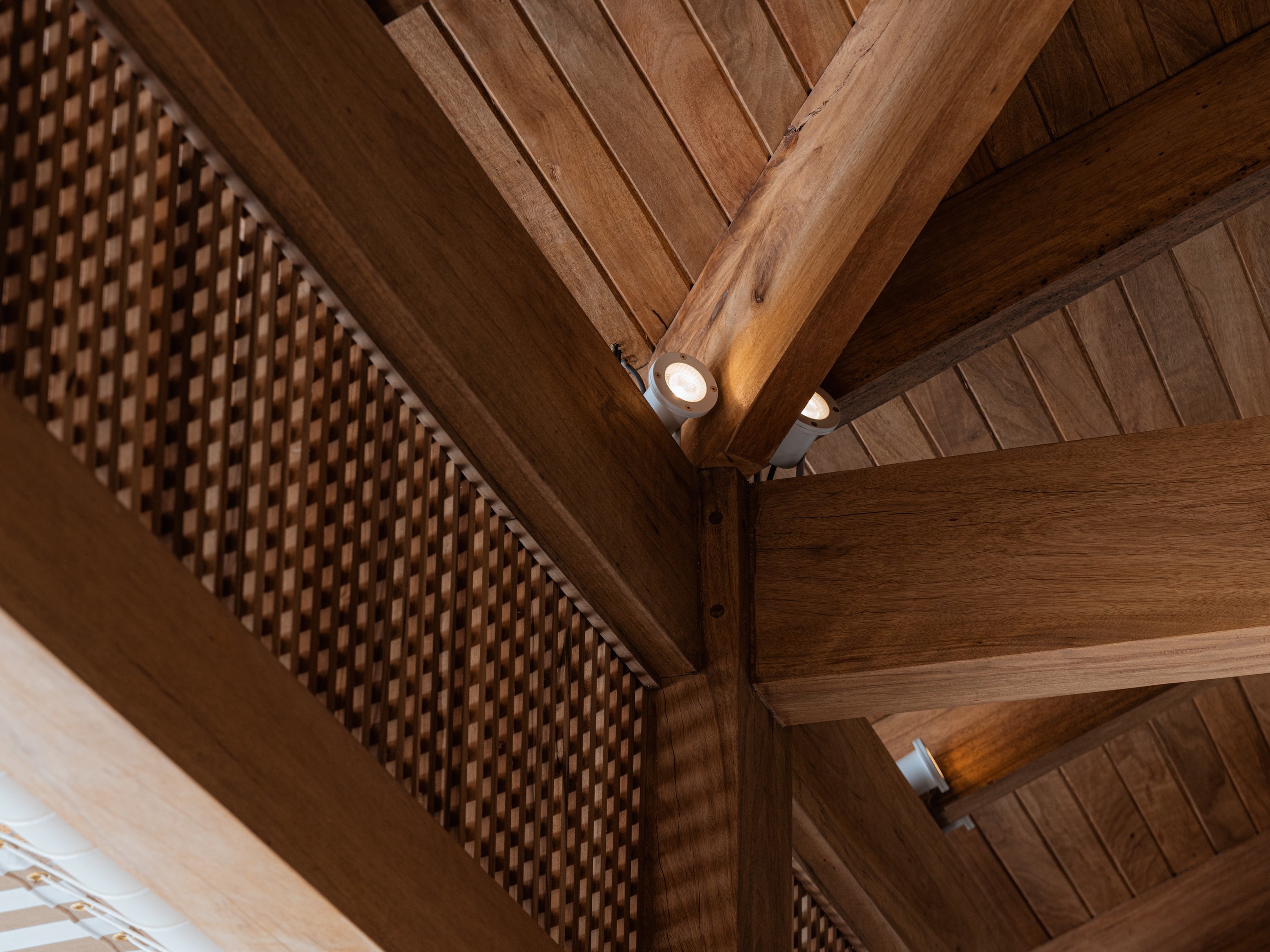 Vigas y columna de madera bajo un cielo de tablilla